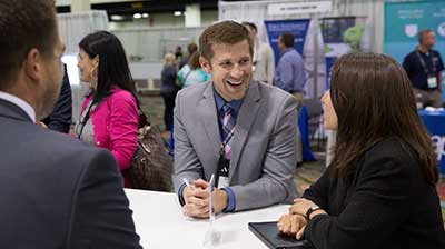 Business people at a conference chatting at a stand