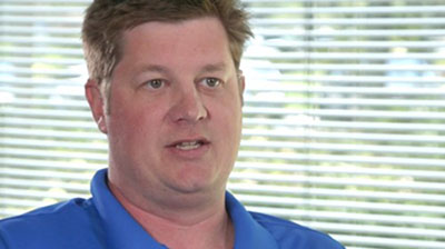 A man in a blue polo being interviewed