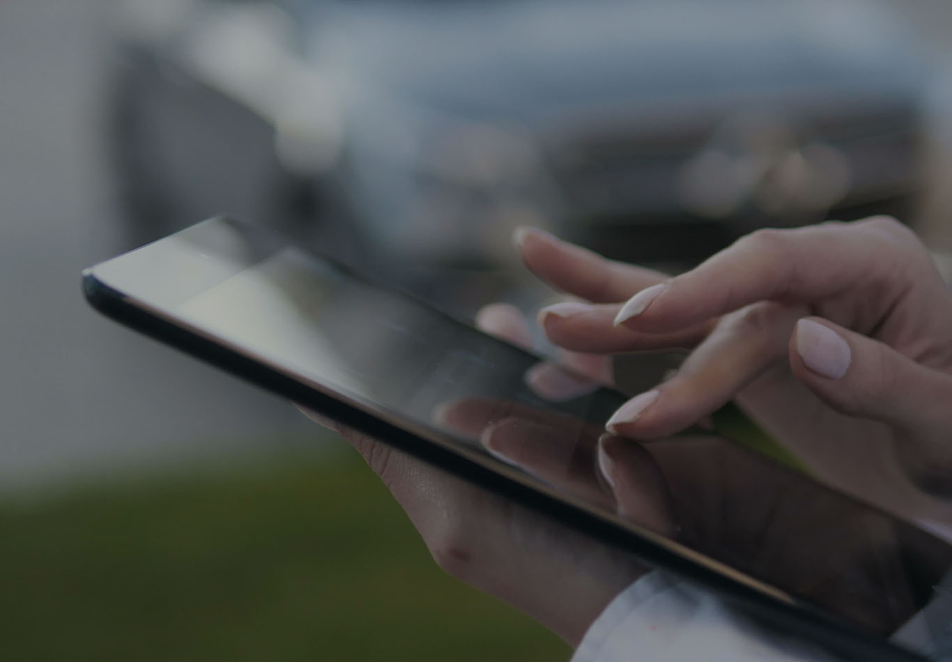 A pair of hands are interacting and holding a tablet. 